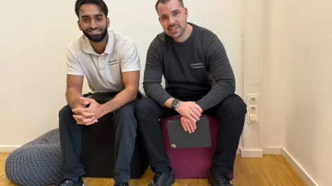 Zwei Mitarbeiter von netzwerkfähig sitzen mit Notebook in der Wartezone