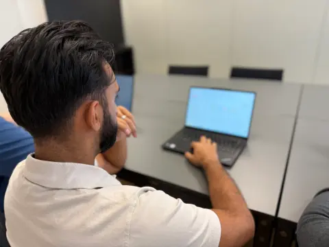 Blick über die Schulter auf ein Notebook im Besprechungsraum