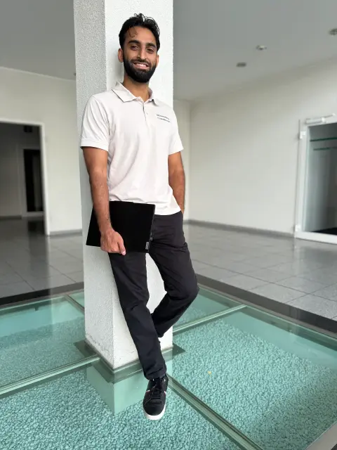 Mitarbeiter von netzwerkfähig mit Notebook an einer Säule im Foyer