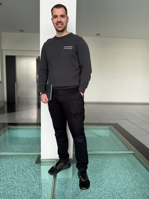 Mitarbeiter von netzwerkfähig mit Notebook an einer Säule im Foyer