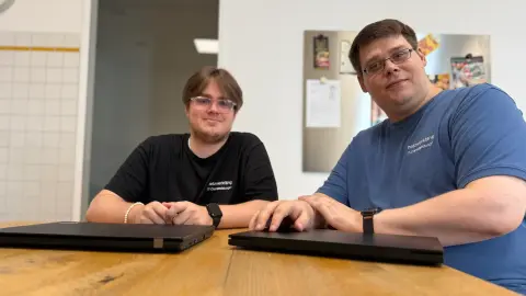 Zwei Mitarbeiter von netzwerkfähig am Tisch in der Büroküche