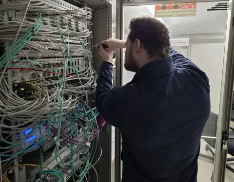 Mitarbeiter von netzwerkfähig arbeitet am offenen Serverrack mit Netzwerkverkabelung