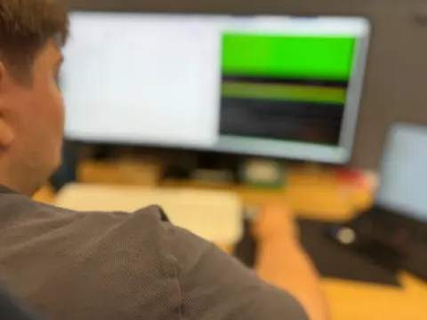 Mitarbeiter von netzwerkfähig am Arbeitsplatz mit Monitor