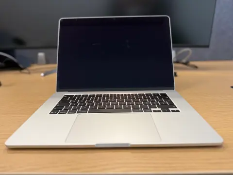 Aufgeklapptes MacBook auf einem Schreibtisch im Büro