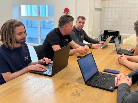 Team von netzwerkfähig mit Notebooks am Besprechungstisch