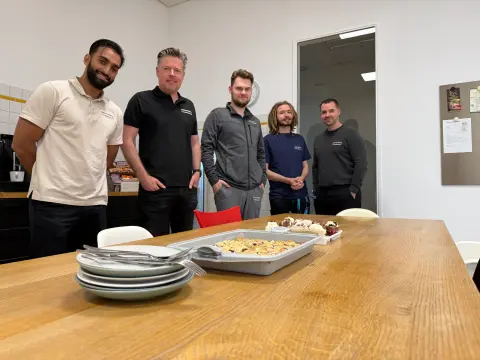 Das Team von netzwerkfähig feiert einen Geburtstag mit Kuchen im Aufenthaltsraum