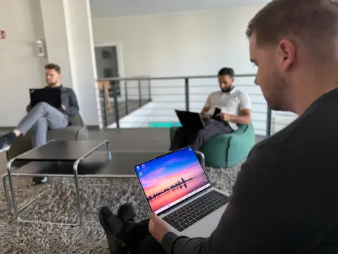 Mitarbeiter arbeiten mit Notebooks in der Lounge des Büros