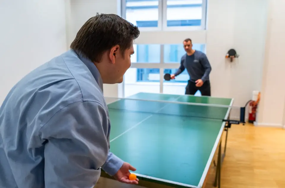 Zwei Mitarbeiter beim Tischtennis spielen.