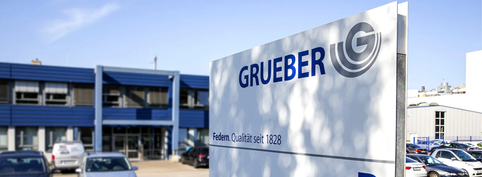 Firmengebäude von Grueber Federn in Hagen mit Unternehmensschild im Vordergrund